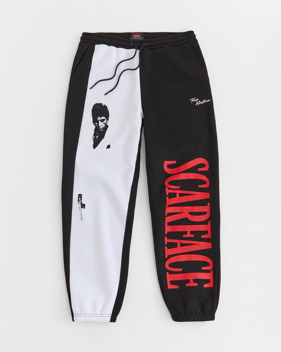 Black and white jogger pants with 'Scarface' text on a light gray background