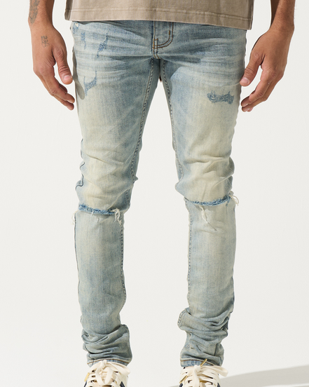 Light blue distressed jeans worn by a person on a white background