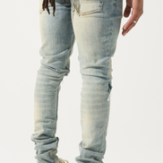 Person wearing light blue jeans and white sneakers with black stripes on a white background