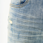 Close-up of a blue denim skirt with a white background