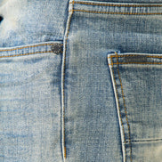Close-up of blue denim fabric with stitching details
