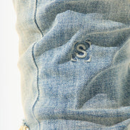 Close-up of a blue denim fabric with a brand logo.