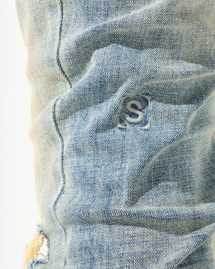 Close-up of a blue denim fabric with a brand logo.
