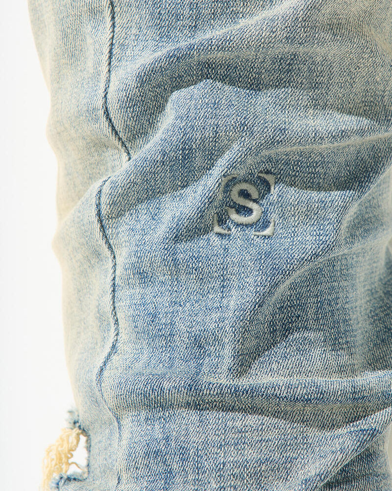 Close-up of a blue denim fabric with a brand logo.
