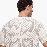 Man wearing a shirt with snake print pattern on a white background
