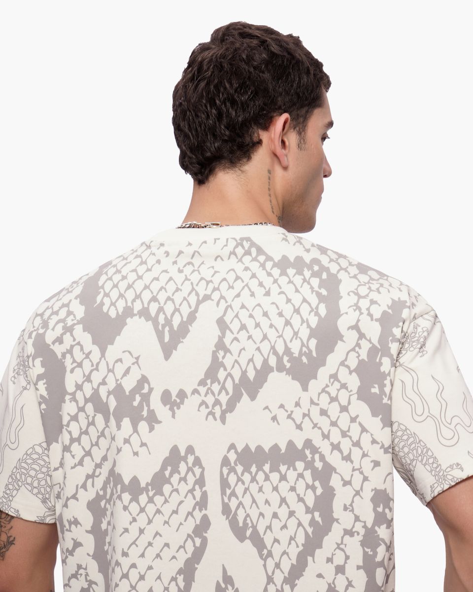 Man wearing a shirt with snake print pattern on a white background