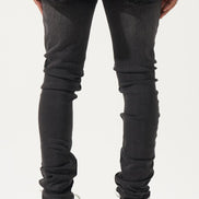 Person wearing black jeans and black sneakers on a white background