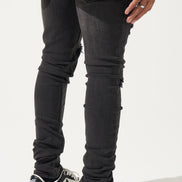 Person wearing black jeans and black sneakers with white star designs on a white background