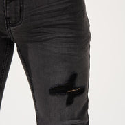 Black distressed jeans on a white background