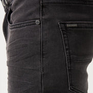 Close-up of black pants with a brand label on a white background