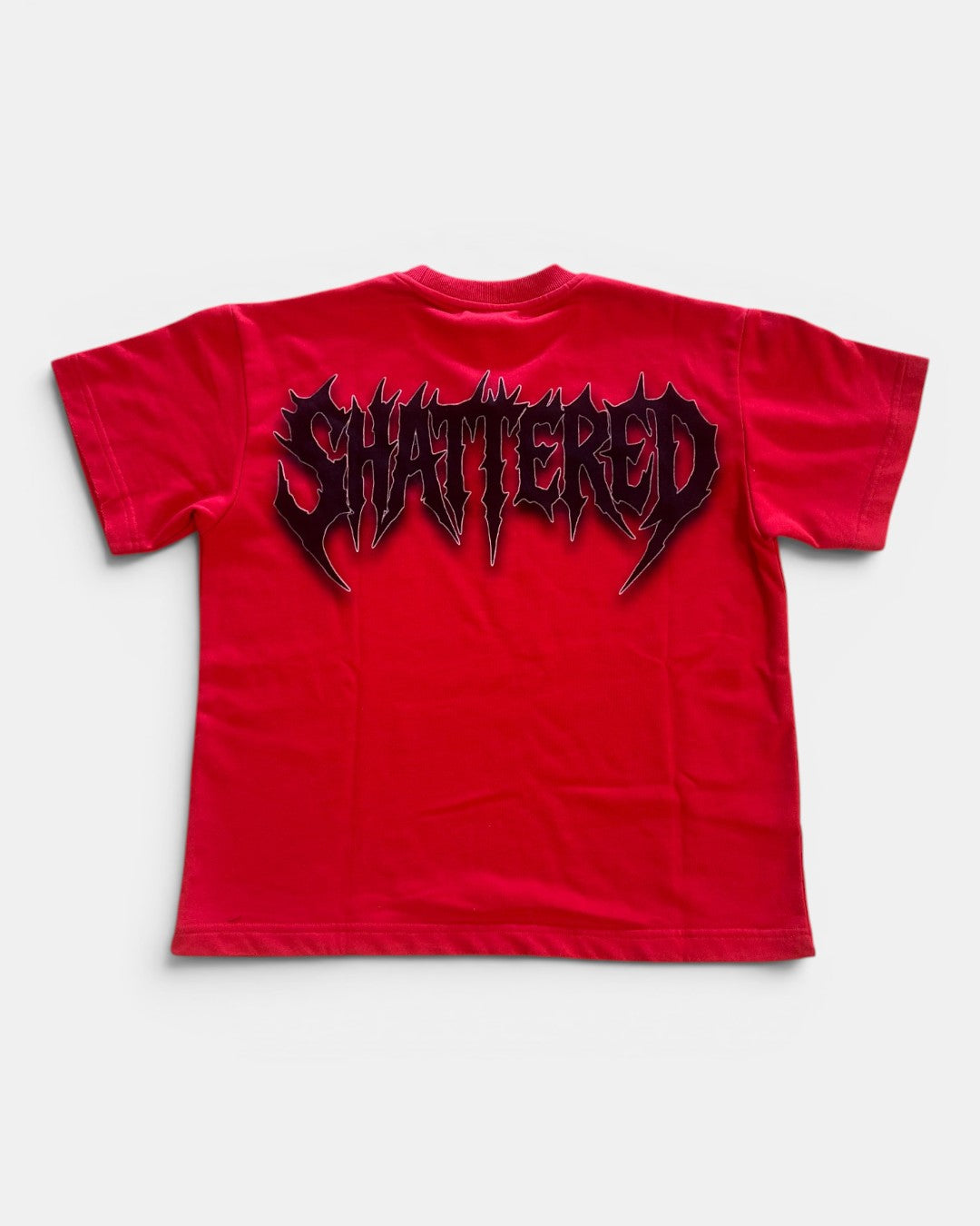 Red t-shirt with 'SHATTERED' graphic on a white background
