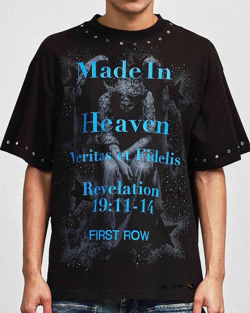 Person wearing a black t-shirt with text and graphics on a plain background