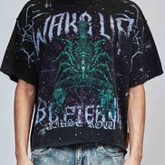 Person wearing a black graphic t-shirt with a green alien design and text.