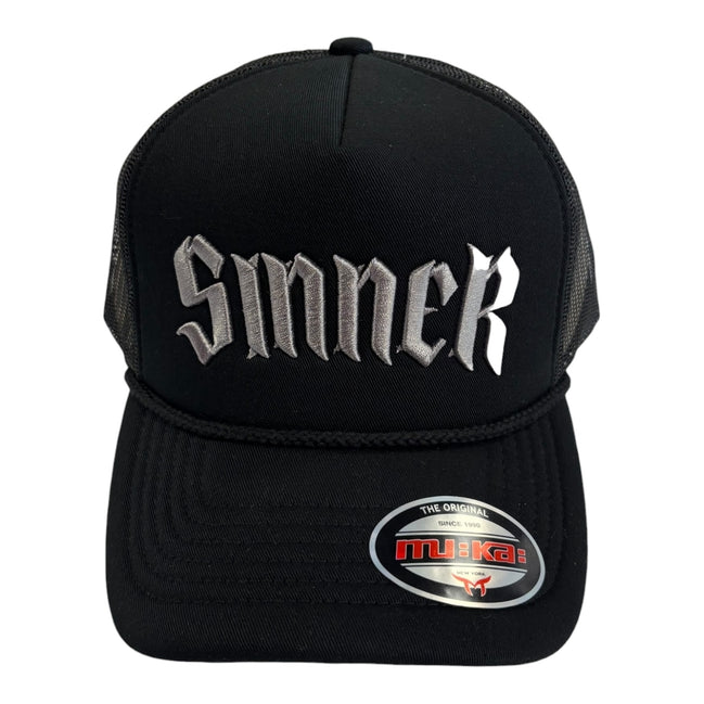 Black cap with 'Smerk' text and MUKA logo on a white background