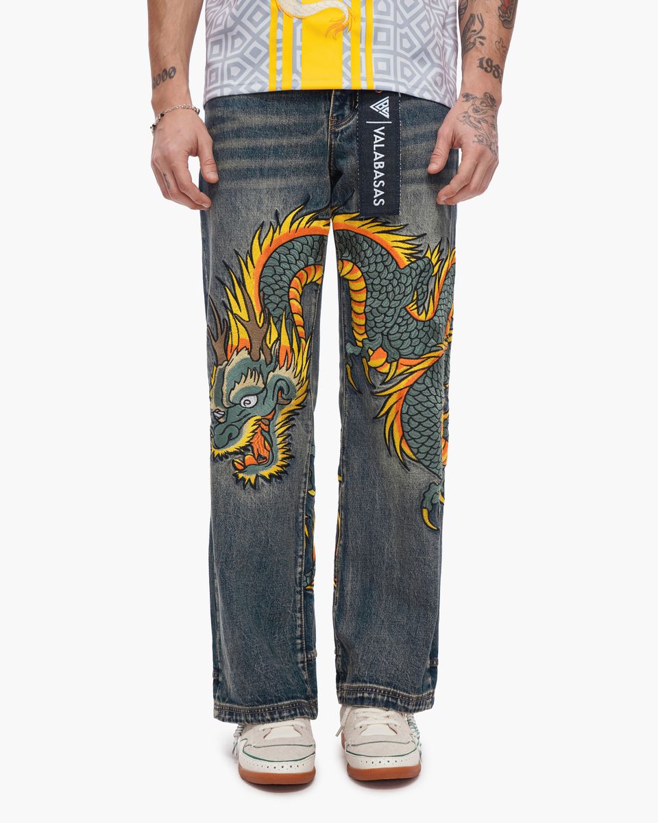 Denim jeans with a dragon design on a white background