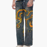 Denim pants with a dragon design worn by a person on a white background