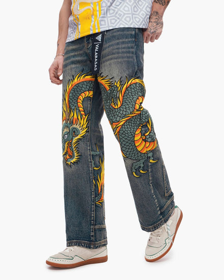 Person wearing blue jeans with a dragon design on a white background