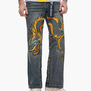 Person wearing jeans with a dragon design and branding.