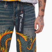 Denim pants with dragon design and Valabasas tag, person wearing them.