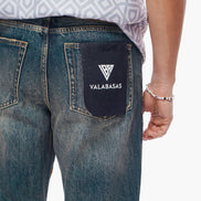 Blue jeans with a visible brand logo on the back pocket against a white background