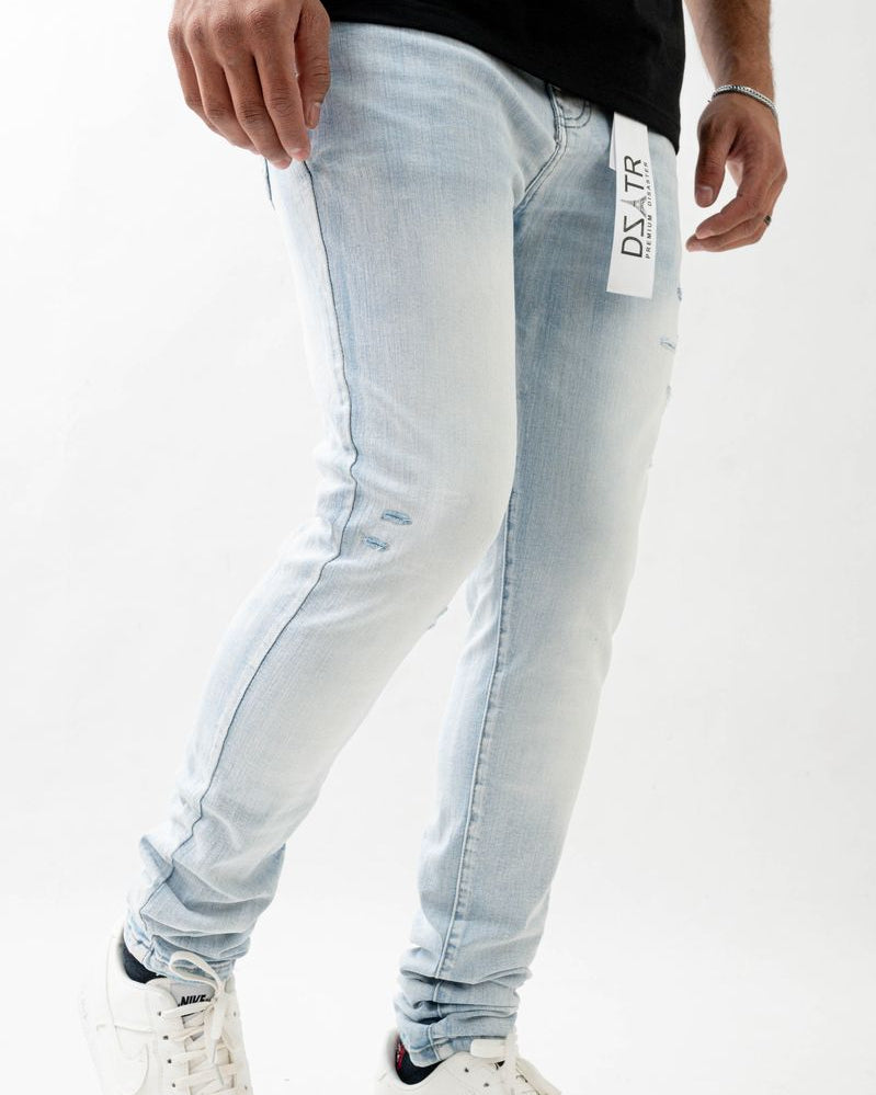 Light blue jeans with a brand label worn by a person on a white background