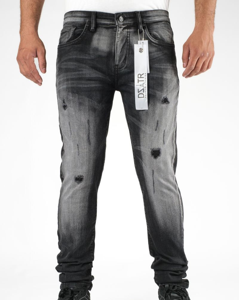 Black distressed jeans with a brand tag on a white background