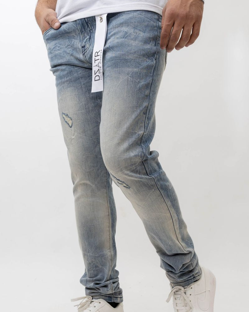 Person wearing light blue distressed jeans with a white background