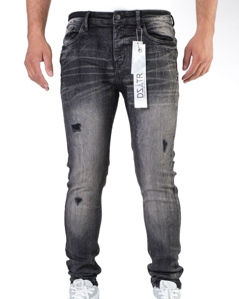 Gray distressed jeans with a brand tag on a white background