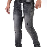 Black distressed jeans with a brand tag on a white background