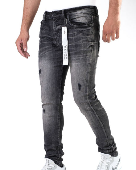 Black distressed jeans with a brand tag on a white background