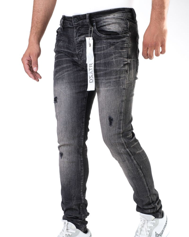Black distressed jeans with a brand tag on a white background