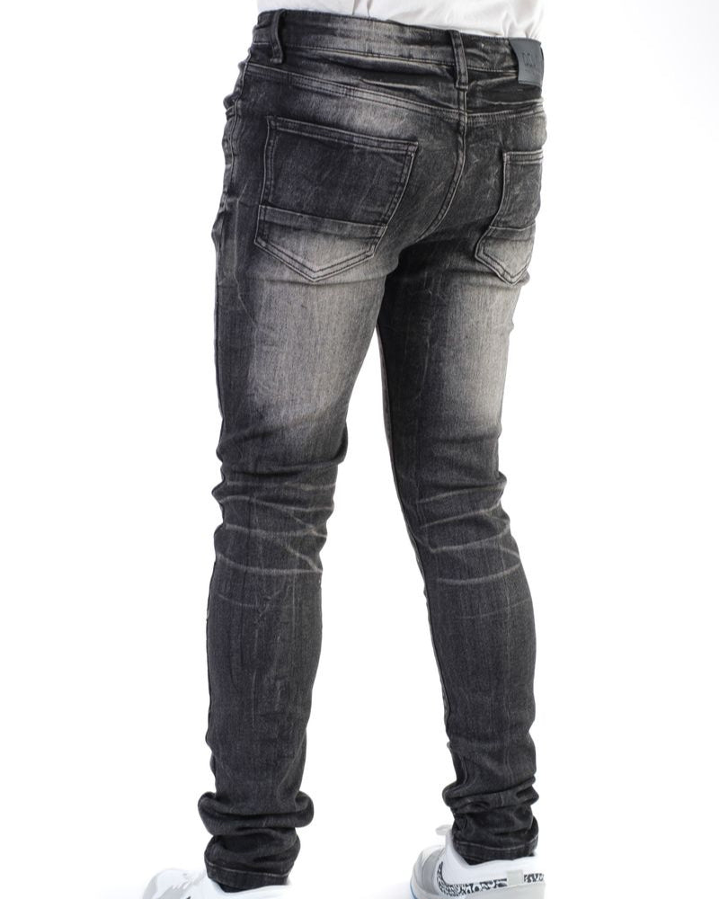 Black jeans worn by a person on a white background