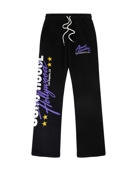 Black sweatpants with white drawstrings, featuring purple and white graphic text on the left leg and a purple logo on the right thigh, displayed against a solid white background.