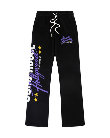 Black sweatpants with white drawstrings, featuring purple and white graphic text on the left leg and a purple logo on the right thigh, displayed against a solid white background.