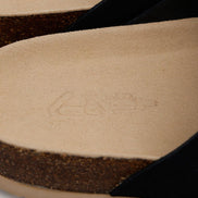 Close-up of a sandal sole with a brand logo on a white background
