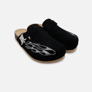 Pair of black clogs with decorative elements on a white background