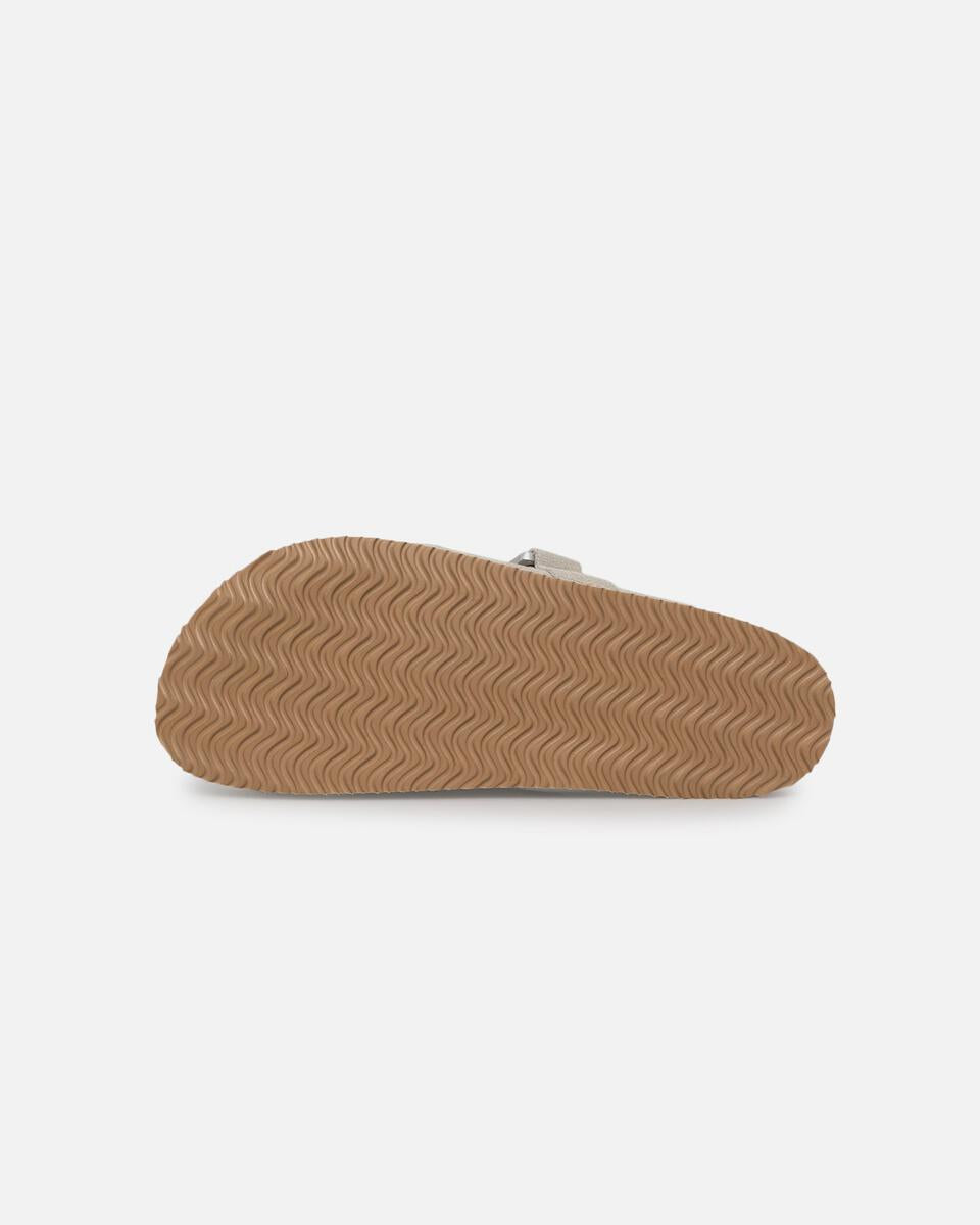 Black sandal with a textured sole on a light gray background
