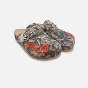 Pair of camouflage-patterned clogs with orange accents on a white background