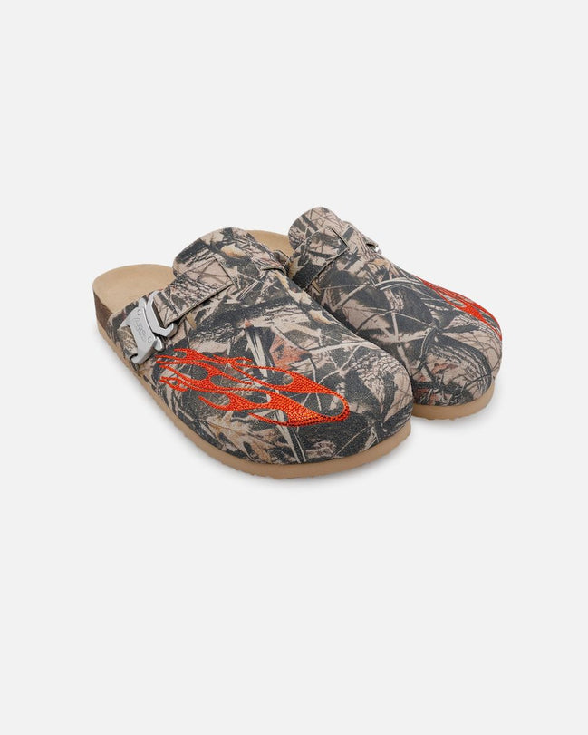 Pair of camouflage-patterned clogs with orange accents on a white background