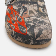 Camouflage-patterned shoe with orange flame design on a white background