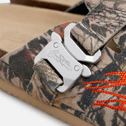 Camouflage sandal with a metal buckle and orange laces on a white background