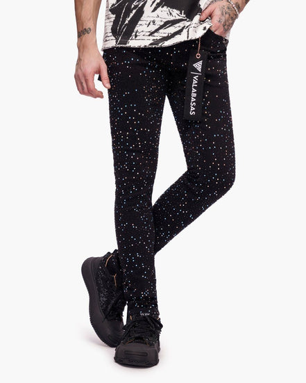 Person wearing black leggings with white speckles and a visible brand logo on a white background