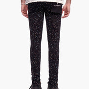 Black leggings with white speckles worn by a person on a white background