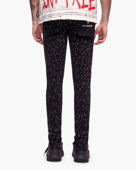 Black leggings with white speckles worn by a person on a white background