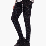Black leggings with white speckles worn by a person on a white background