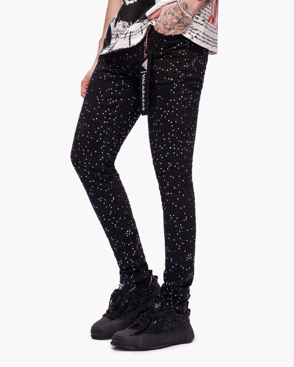 Black leggings with white speckles worn by a person on a white background