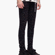 Person wearing black glittery pants with a white background