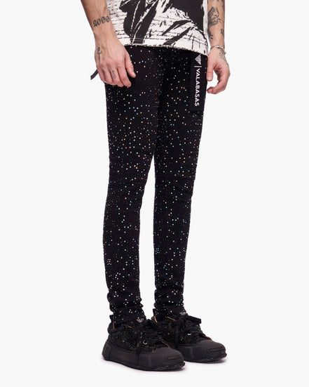 Person wearing black glittery pants with a white background
