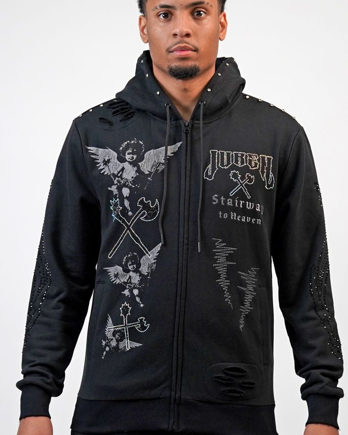 Person wearing a black hoodie with graphic designs on a white background