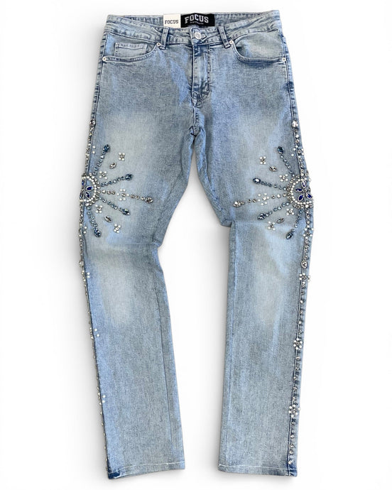 Light blue jeans with decorative embellishments on a white background